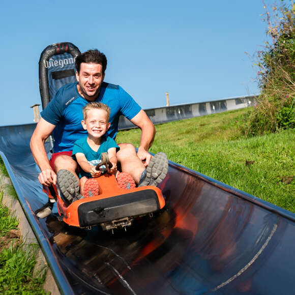 Vater und Sohn im Sommerrodel am Hündle.