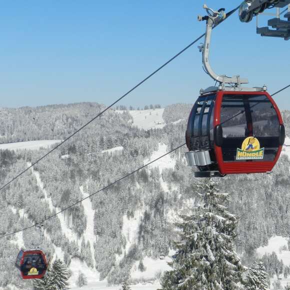 Zwei Gondeln der Hündlebahn fahren im Winter.