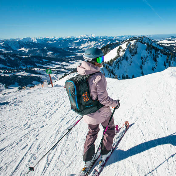 Skifahrerin an einem sonnigen Tag auf den verschneiten Pisten.
