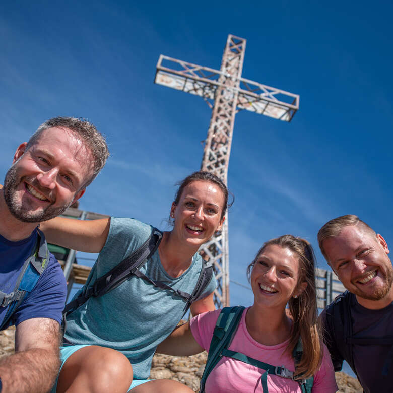 Wanderer mit dem Hochgrat-Gipfelkreuz.