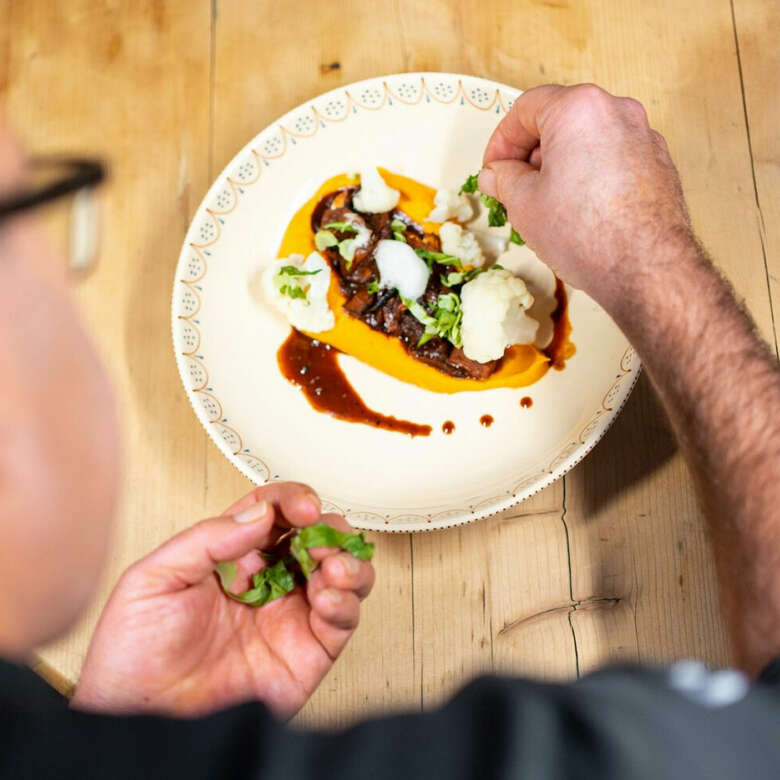 Koch Thomas Glässing richtet Jackfrucht-Ragout mit Süßkartoffelpüree an