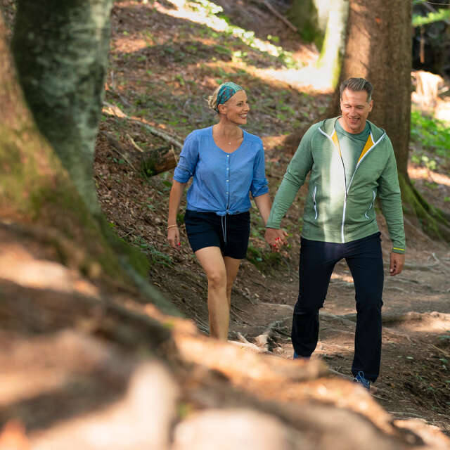 Paar wandert fröhlich durch den Wald.