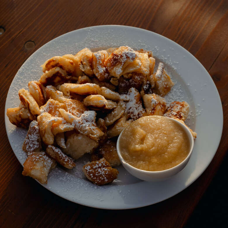 Frischer Kaiserschmarrn mit Apfelmus im Allgäuer Biergarten.