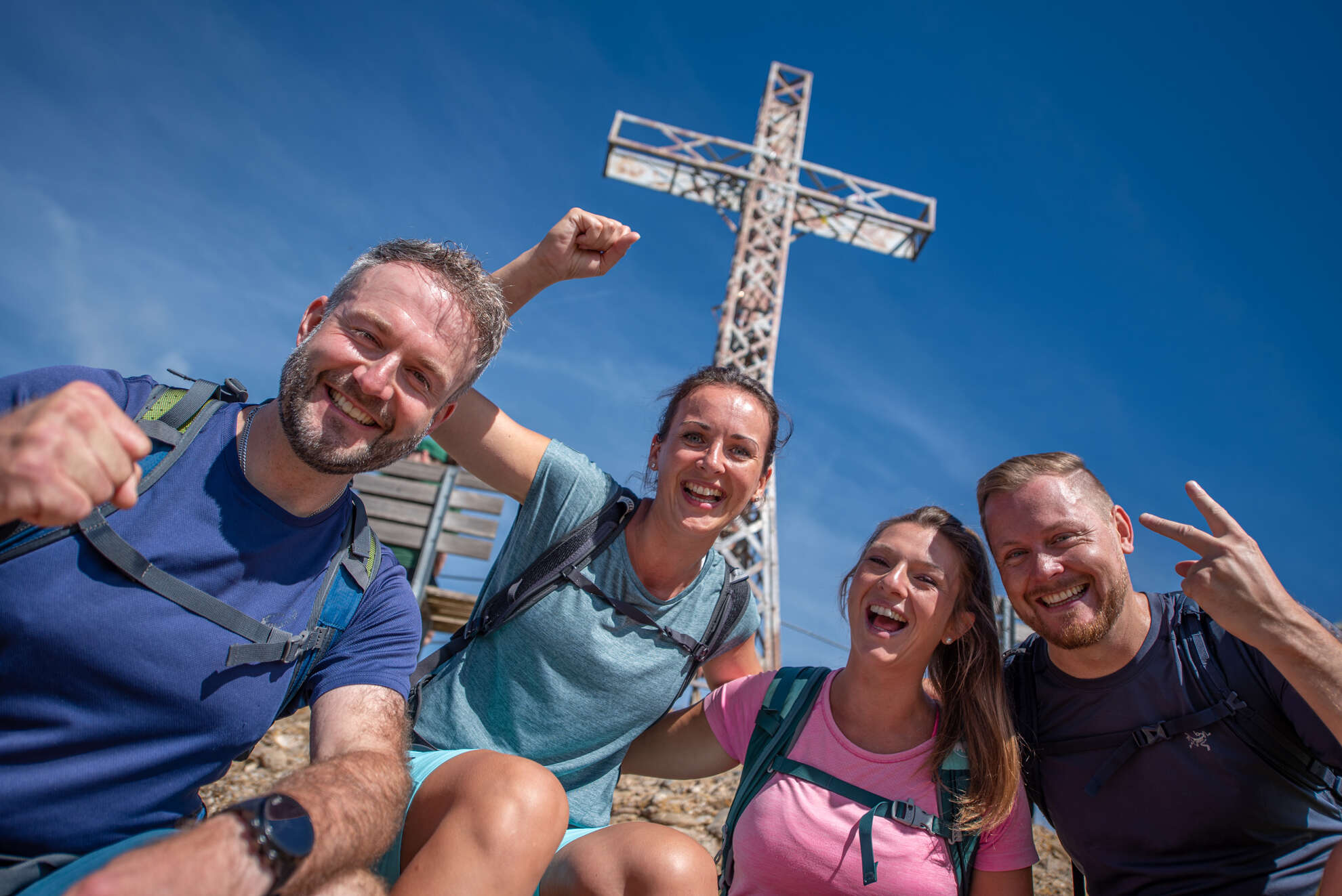 Freundesgruppe macht ein Selfie vor dem Gripfelkreuz am Hochgrat