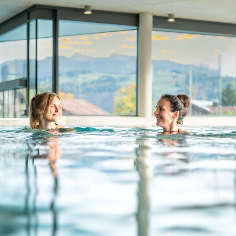 Schwimmen im Pool Zwei Frauen schwimmen in einem Pool.