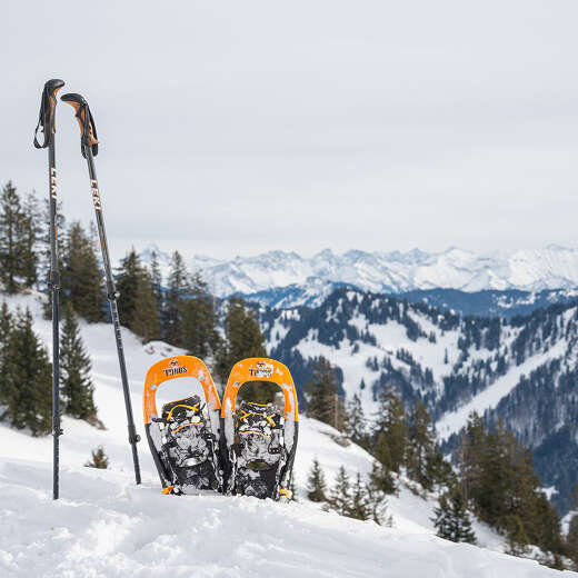 Schneeschuhe im Schnee vor dem verschneiten Panorama der Allgäuer Alpen