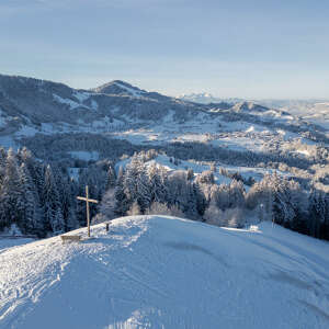 Schnee auf dem Hündle-Gipfel mit Weitblick über die verschneiten Berge und Landschaft.