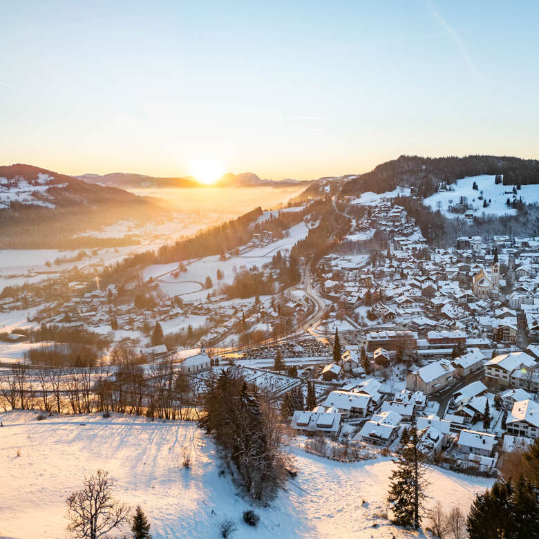Verschneiter Ort Oberstaufen im Sonnenuntergang