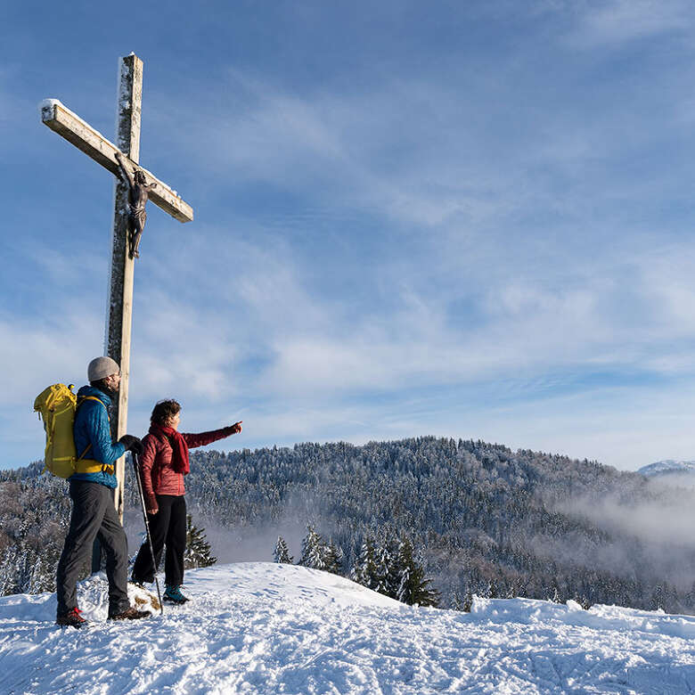 Winterwanderung zur Juget Wanderer am verschneiten Gipfel der Juget-Höhe bei Oberstaufen mit Bergpanorama